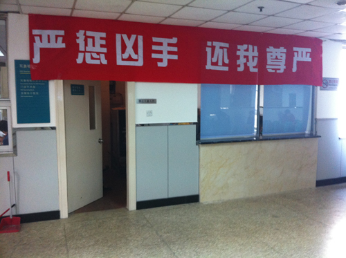 A red banner hangs in the otolaryngology department of Beijing Tongren Hospital on Sept. 20, 2011. The banner reads: “Sternly punish the murderer, give me back my dignity.” [By Daniel Xu/China.org.cn]